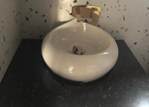a white sink in a bathroom with a gold faucet at THE RiYASAT SARISKA in Ajabgarh +43 photos