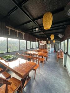 a restaurant with wooden tables and chairs and windows at Trúc Nhân Hotel in Dồng Văn +14 photos