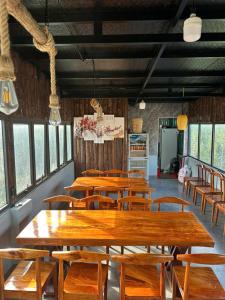 a row of tables and chairs in a room with windows at Trúc Nhân Hotel in Dồng Văn
