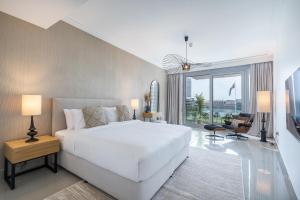 a bedroom with a white bed and a large window at Vogue Vacation Homes, Downtown Opera Grand near Burj Khalifa and Dubai Mall, Two Bedroom Apartment with Large Balcony and Burj Khalifa view, Access to all Amenities in Dubai