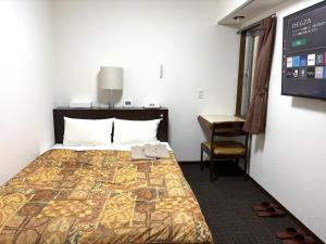 a hotel room with a bed and a desk at Hotel Tokeidai in Sapporo
