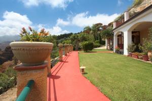 a red path in front of a house with a vase at Villa Eleanto in Cefalù