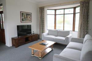 Una sala de estar con dos sofás y un televisor. en Puffers Inn, en Loganholme 45 fotos más