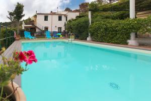 a large swimming pool with blue water in a yard at Villa Eleanto in Cefalù
