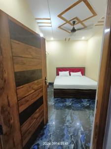 a bedroom with a bed and a open door at Hotel Maa Dham Palace in Ayodhya