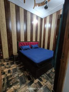 a bedroom with a blue bed with a striped wall at Hotel Maa Dham Palace in Ayodhya +9 photos