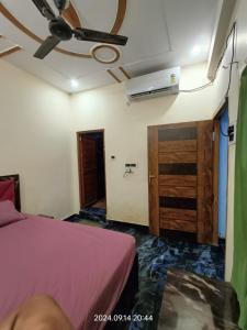 a bedroom with a bed and a ceiling fan at Hotel Maa Dham Palace in Ayodhya +9 photos