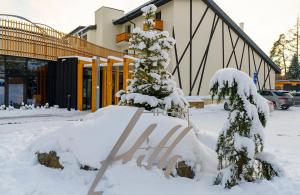 a snow covered sign in front of a building at Hotel Hills in Tatranská Lomnica
