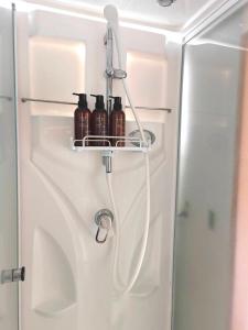 Un pequeño refrigerador blanco con botellas en un estante. en Wonderwall美好境界 日本藏王館, en Yamagata