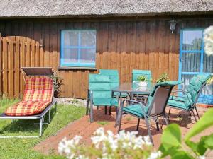 un patio con tavolo, sedie e una recinzione di Ferienhaus An der Heide a Neuendorf Heide