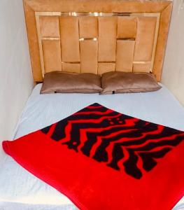 een zwart-rode deken op een bed bij Omega guest houses in Amritsar +5 foto's