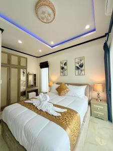 a bedroom with a large white bed with a towel on it at PS House Bangtao in Bang Tao Beach