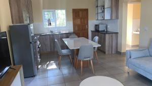 a kitchen and a living room with a table and chairs at Vista Alta Serma in Ponta Malangane