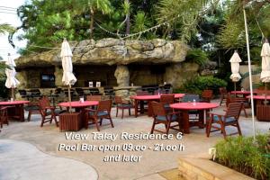 eine Terrasse mit Tischen und Stühlen und ein Steingebäude in der Unterkunft View Talay Residence 6 Wongamat Beach in Pattaya North