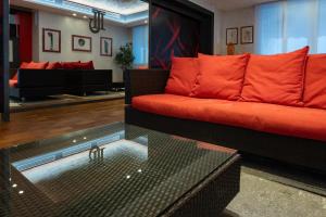 ein Wohnzimmer mit einem roten Sofa und einem Glastisch in der Unterkunft Jet Hotel, Sure Hotel Collection by Best Western in Gallarate + 56 Fotos
