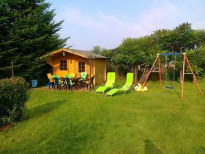 un patio con un parque infantil con sillas y un columpio en Ferienwohnungen Hohen Niendorf bei Kühlungsborn, en Hohen Niendorf