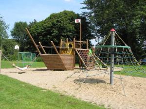 un parque con un patio de juegos con un columpio en Ferienwohnungen Hohen Niendorf bei Kühlungsborn, en Hohen Niendorf