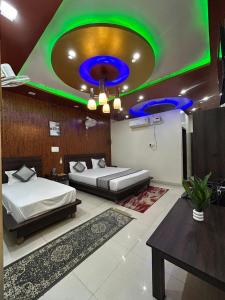 Un dormitorio con dos camas y un techo verde. en mshotel Loharu, en Lohāru