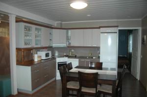 a kitchen with white cabinets and a table and chairs at Chalets UkkoHerra 1 & 2 in Ruka