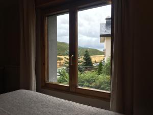 a bedroom window with a view of a mountain at Hotel La Braña in San Isidro