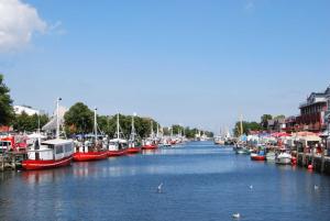 een groep boten is aangemeerd in een rivier bij Ferienwohnung Warnemünde Altstadt (RC) in Warnemünde