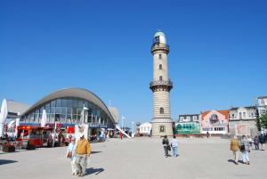 een vuurtoren in een stad waar mensen rondlopen bij Ferienwohnung Warnemünde Altstadt (RC) in Warnemünde