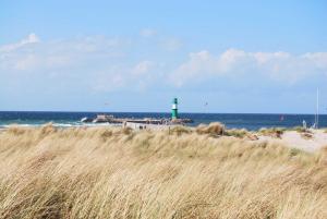 een vuurtoren op het strand met een veld van hoog gras bij Ferienwohnung Warnemünde Altstadt (RC) in Warnemünde