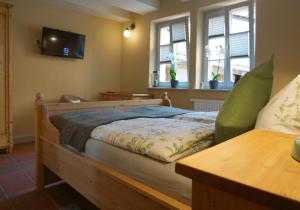 a bedroom with a wooden bed with a tv on the wall at Klopstock´s Herberge in Quedlinburg