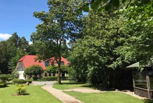 ein Garten mit einem Haus und einem roten Dach in der Unterkunft Ferienwohnung Seeblick in Waren (Müritz)
