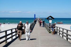 eine Gruppe von Menschen, die einen Pier am Strand entlang gehen in der Unterkunft Urlaub in Wieck in Wieck + 17 Fotos