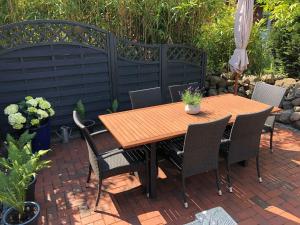 einen Holztisch und Stühle auf einer Backsteinterrasse in der Unterkunft Urlaub in Wieck in Wieck