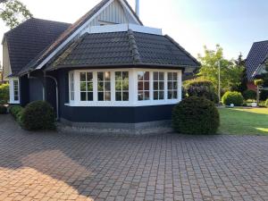 ein Haus mit einem schwarzen Dach und einer steinernen Einfahrt in der Unterkunft Urlaub in Wieck in Wieck