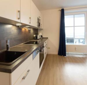 a kitchen with a sink and a counter top at Fabelhaft am Meer in Timmendorfer Strand