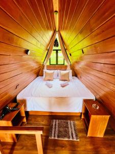 Un dormitorio con una cama en una habitación de madera. en Eco Cabana Bellwood Kandy, en Nikawatawana