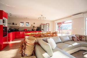 Una sala de estar con un sofá y una cocina. en Chambre - Joubarbe, en Aroue