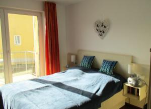 a bedroom with a bed and a large window at Apartment Fledermäuschen in Graal-Müritz