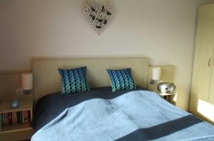 a bedroom with a bed with blue sheets and pillows at Apartment Fledermäuschen in Graal-Müritz +6 photos