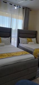 Dos camas una al lado de la otra en un dormitorio. en Havy Homes 2 Bedroom Apartment Bamburi, en Bamburi