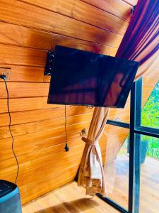 lámpara en una habitación con pared de madera en Eco Cabana Bellwood Kandy, en Nikawatawana