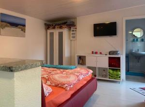 Zimmer mit einem Bett und einer Theke mit einem TV in der Unterkunft Bungalow mit Terrasse in Graal-Müritz