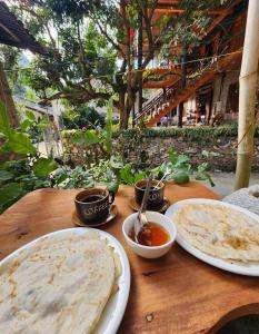 ein Holztisch mit zwei Tellern mit Essen darauf in der Unterkunft A Tứng House Bản Giốc in Trùng Khánh