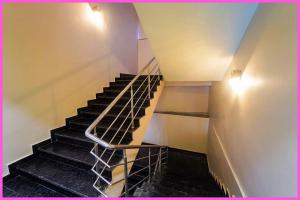 una escalera en un edificio con barandilla de metal en Rooftop Sea View & BALCONY ROOMS RR In Near JNear Jagannath Temple - Golden Beach- Swargadwar Beach - Bengali Market - Free Wi-fi and parking- Fully Air Conditioning Rooms - Best Hotel, en Puri