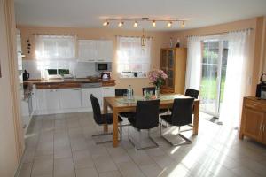 een keuken met een houten tafel en zwarte stoelen bij Ferienhaus Seeblick bei Dranske in Lancken