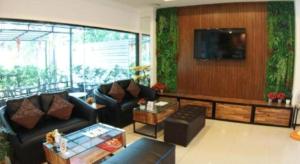 Una sala de estar con sofás y un televisor de pantalla plana. en P Bliss Hotel, en Phayao