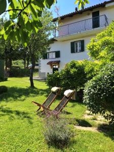 a bench in the grass in front of a house at I Calleri Garden and Rooms in Millesimo