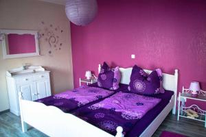 een paarse slaapkamer met een wit bed en paarse lakens bij Ferienwohnung Sassnitz mit Meerblick in Sassnitz