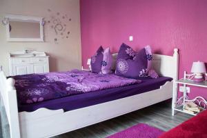 een paarse slaapkamer met een wit bed met paarse kussens bij Ferienwohnung Sassnitz mit Meerblick in Sassnitz +27 foto's