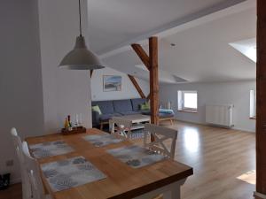 ein Esszimmer und ein Wohnzimmer mit einem Esstisch in der Unterkunft Ferienwohnungen Ribnitz-Damgarten (FR) in Ribnitz-Damgarten + 33 Fotos