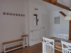 Zimmer mit weißen Wänden, einem Tisch und Stühlen in der Unterkunft Ferienwohnungen Ribnitz-Damgarten (FR) in Ribnitz-Damgarten