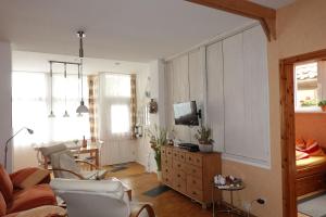 een woonkamer met een bank en een tv bij Ferienwohnung Warnemünde Altstadt (RC) in Warnemünde +42 foto's